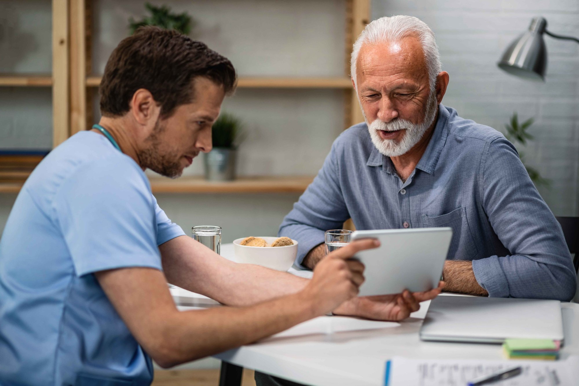 happy-senior-patient-his-doctor-looking-medical-test-results-touchpad-medical-appointment happy-senior-patient-his-doctor-looking-medical-test-results-touchpad-medical-appointment